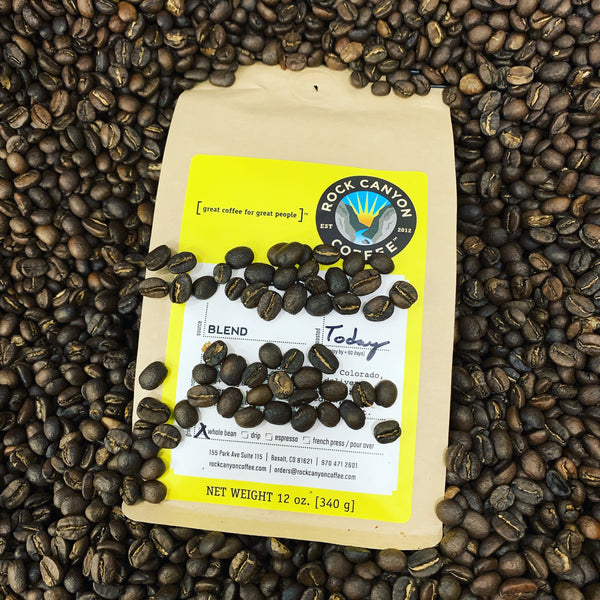 bright yellow bag of day star rock canyon coffee immersed in coffee beans